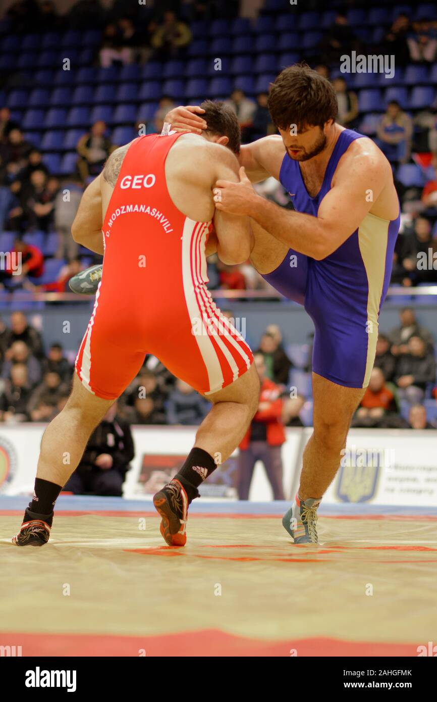 Kiev, Ucraina - 16 Febbraio 2013: Lotta Alen Zaseev, Ucraina, blu vs Modzmanashvili Gruetta, Georgia durante il XIX International freestyle wrestling e femmina torneo di wrestling Foto Stock
