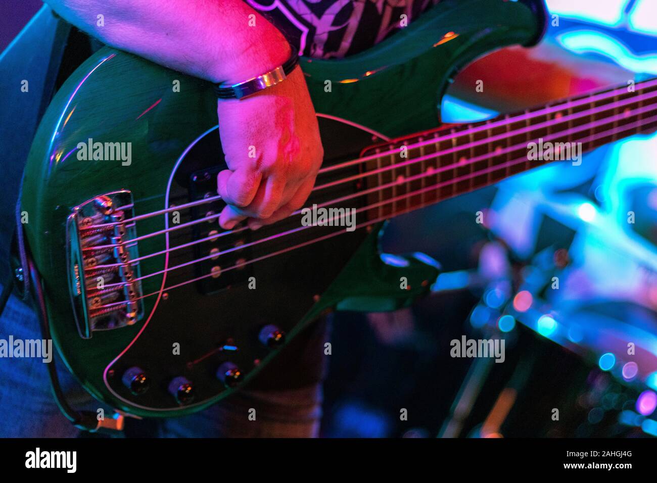 Primo piano della chitarra basso le mani del giocatore, soft il fuoco selettivo, live musica tema Foto Stock