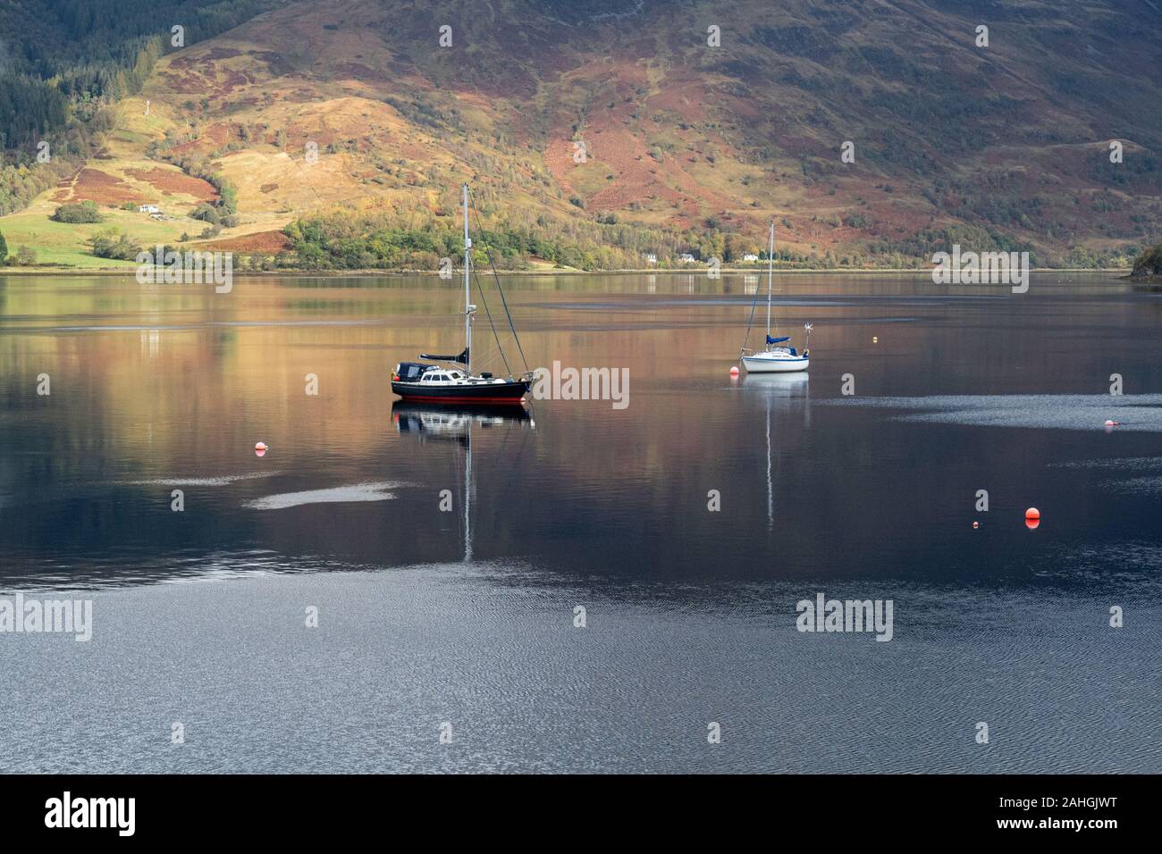 Barche a ancora presso l'ex villaggio di pescatori di Badachro, nelle Highlands occidentali del nord della Scozia Foto Stock