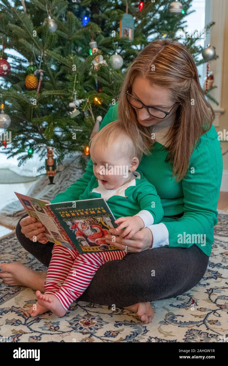 Una madre e suo figlio leggendo la notte prima di Natale Foto Stock