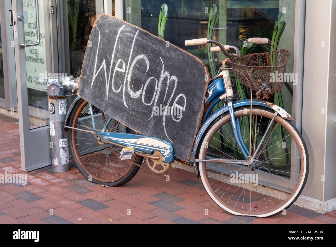 Un segno di benvenuto in sella a una moto che accoglie i clienti nel negozio Foto Stock