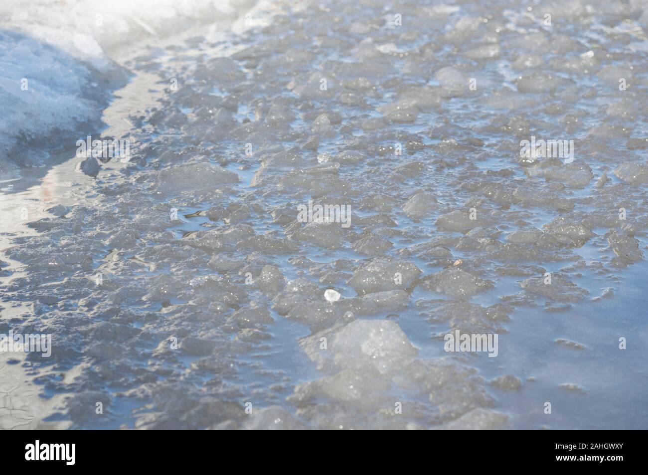 Acqua sulla strada, congelati con pezzi di ghiaccio. Sfondo per il paesaggio invernale. Inverno Russia. Foto Stock