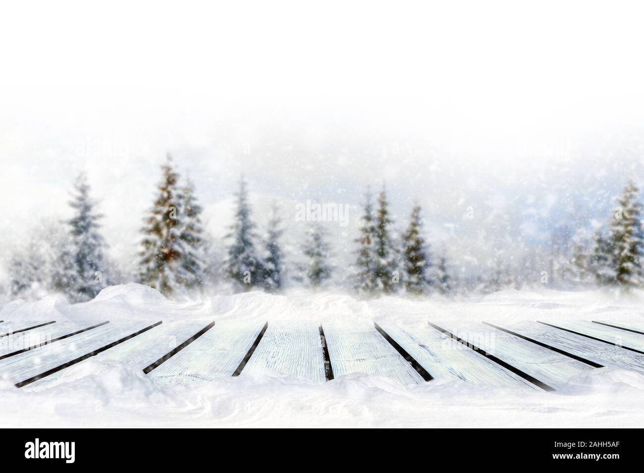 Saluto inverno sfondo sfocato con tavolo in legno e i fiocchi di neve. Merry Сhristmas e nuovo anno ideali Foto Stock