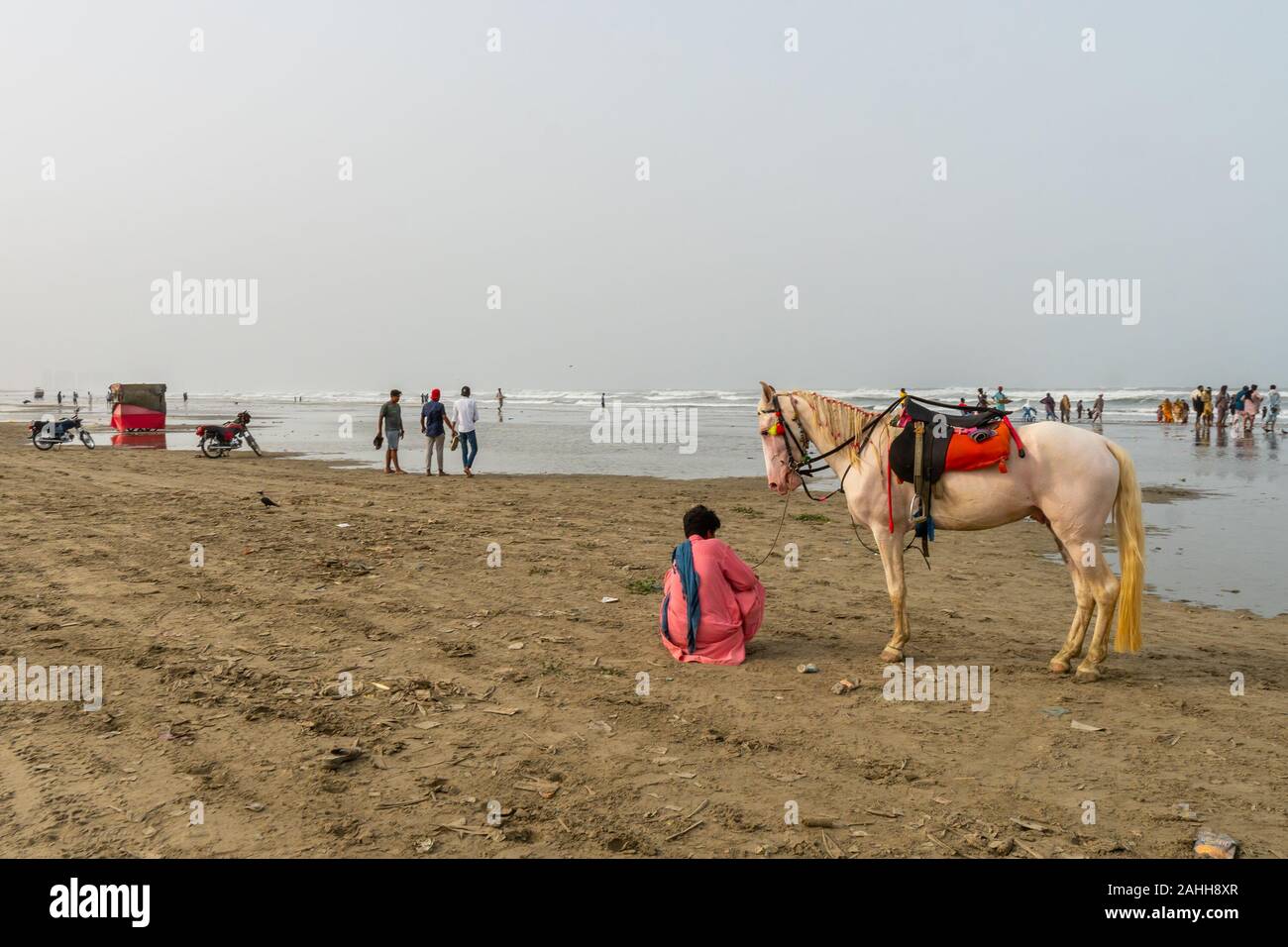 Karachi Clifton Beach mozzafiato vista pittoresca del ragazzo con un cavallo bianco al mattino in un giorno nuvoloso Foto Stock