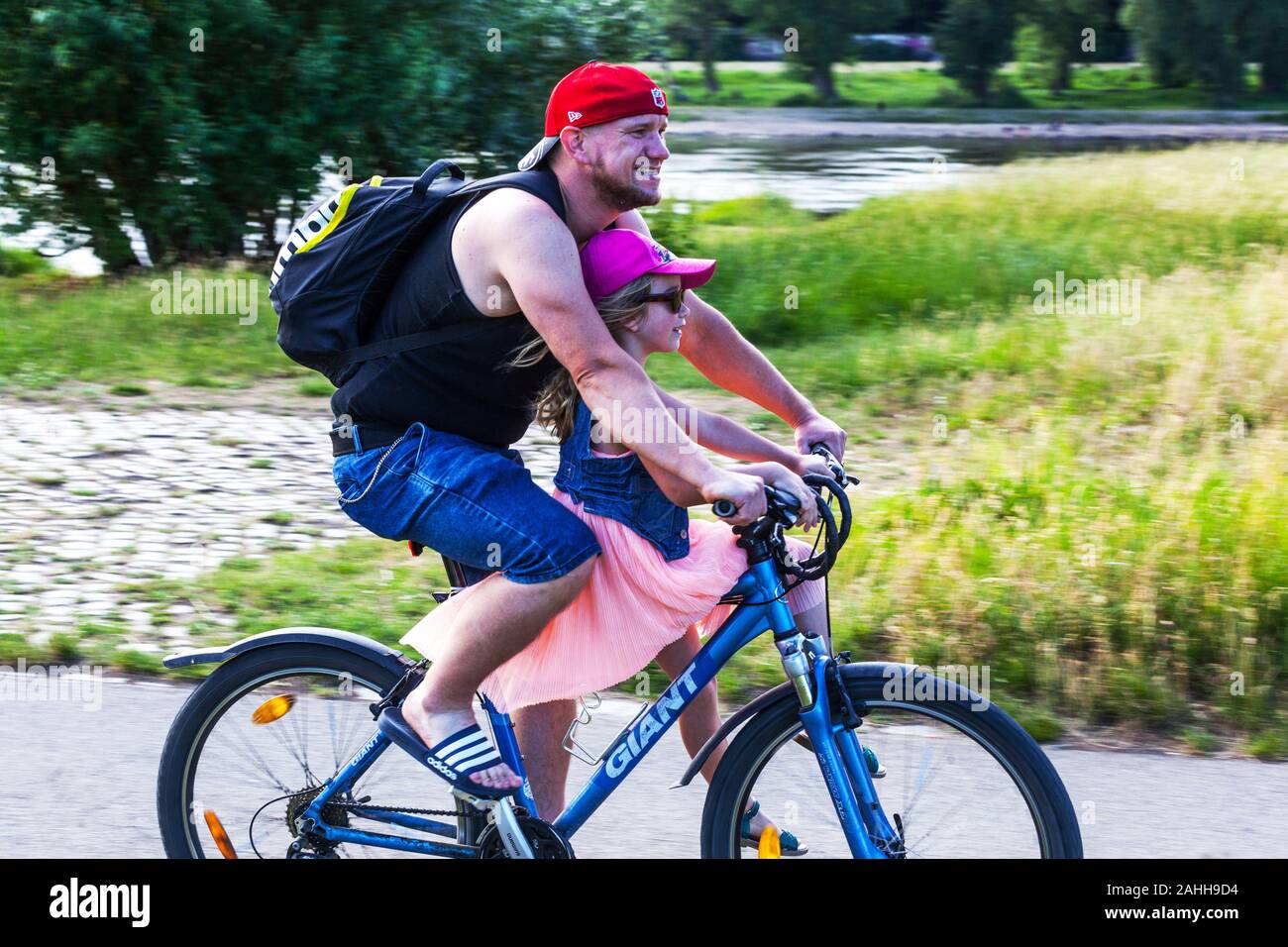 Padre e figlia godendo di un giro in bici su una pista ciclabile lungo il fiume Elba a Dresda in Sassonia Germania uno stile di vita attivo Foto Stock
