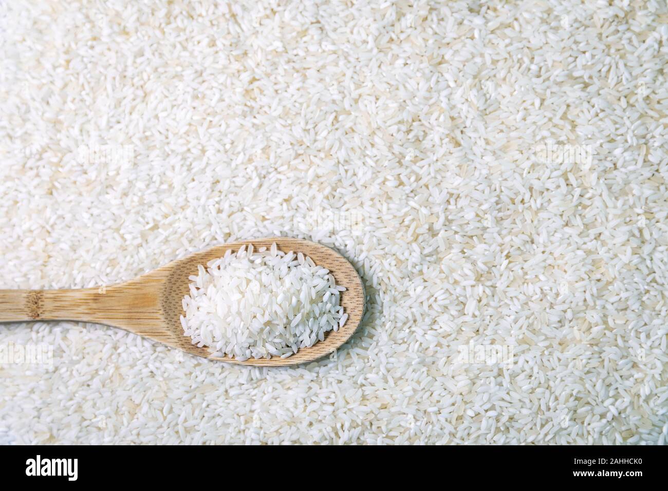 Il riso crudo in cucchiaio di legno con copia spazio. vista superiore Foto Stock