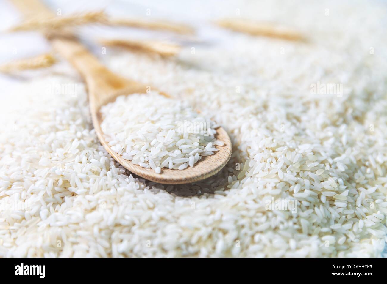 Il riso crudo in cucchiaio di legno in primo piano Foto Stock