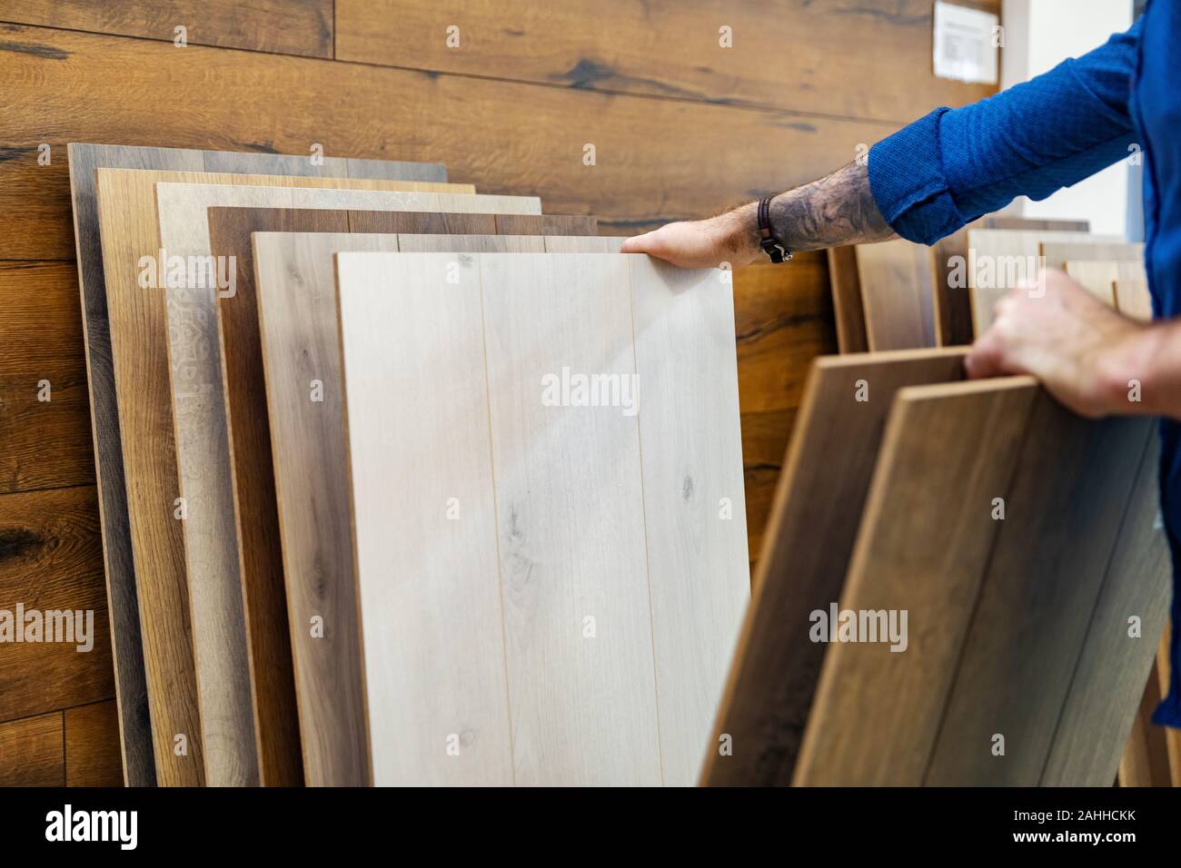 L'uomo la scelta di pavimento laminato per la sua casa nel negozio di pavimentazione Foto Stock