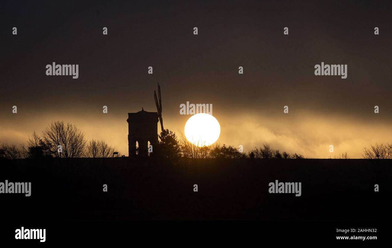 Il sole sorge su Chesterton Windmill nel Warwickshire. Foto Stock