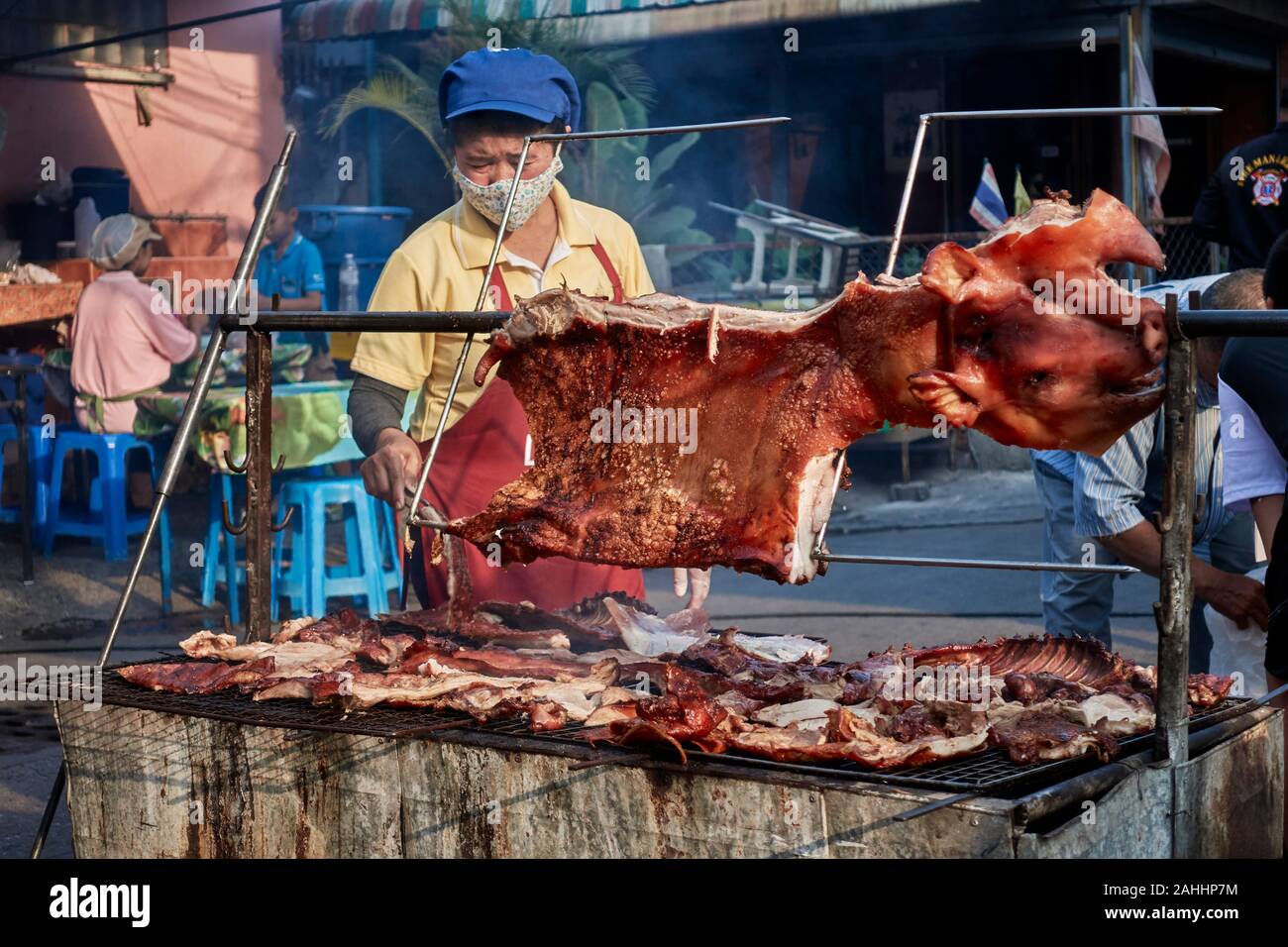 Arrosto di maiale con la donna la cottura in un cibo di strada e del mercato food festival, Na Klua food festival, Pattaya, Thailandia, arrosto di maiale Foto Stock