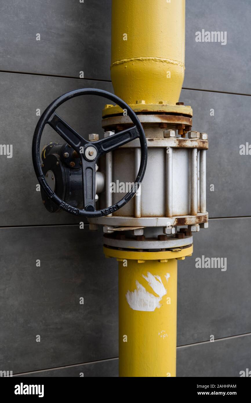 Giallo valvola a saracinesca sul tubo permette di distribuire il gas naturale e disattivarlo se necessario. Una flangia è installata nella tubazione accanto alla gru Foto Stock