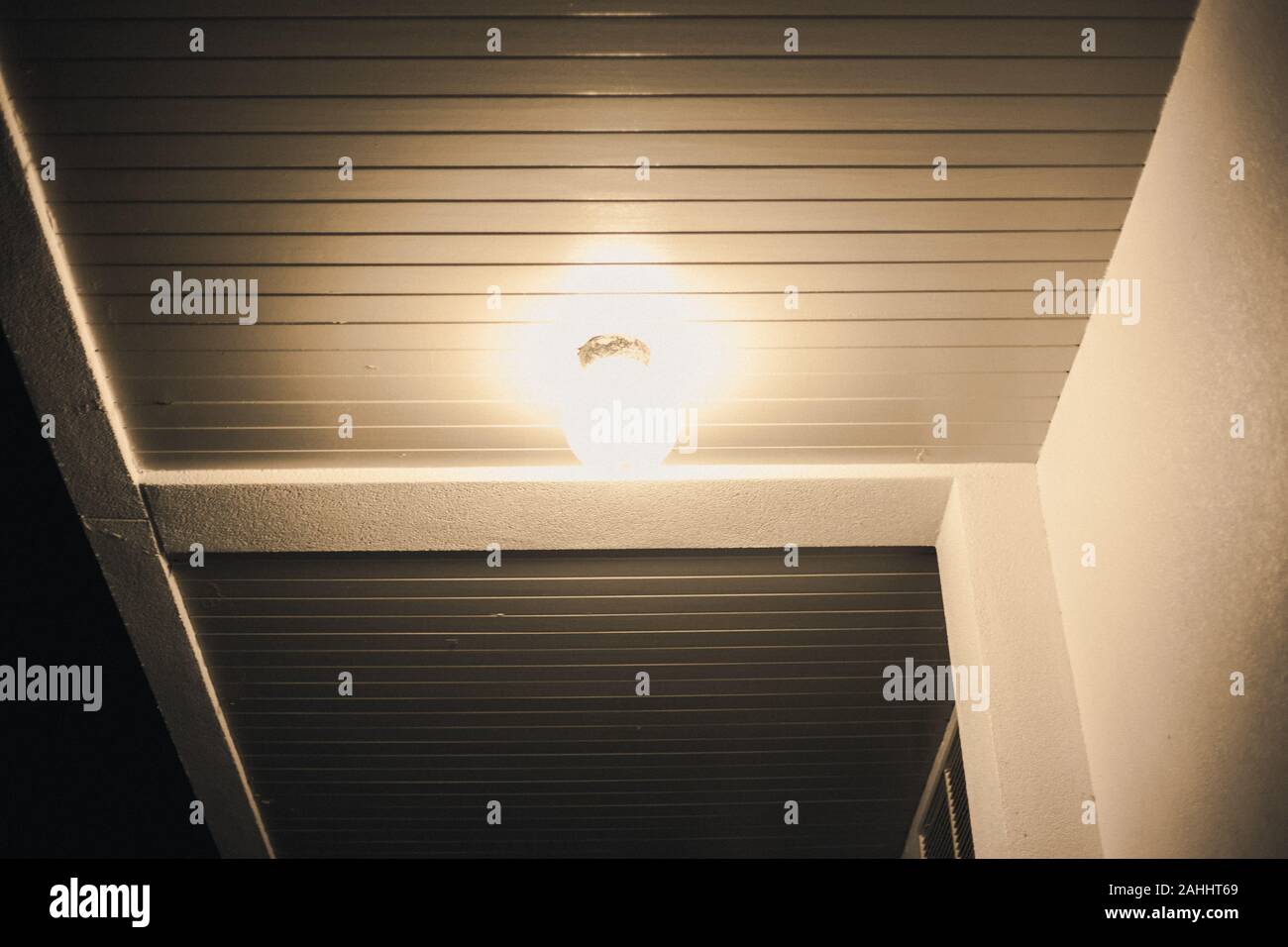 Spia gialla lampada a soffitto splendente di notte Foto Stock
