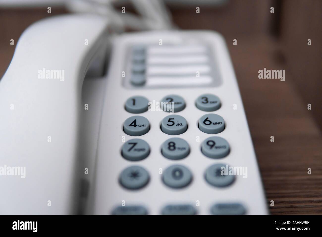 Vintage bianco telefono con battoms grigio su un tavolo marrone in hotel. Foto Stock