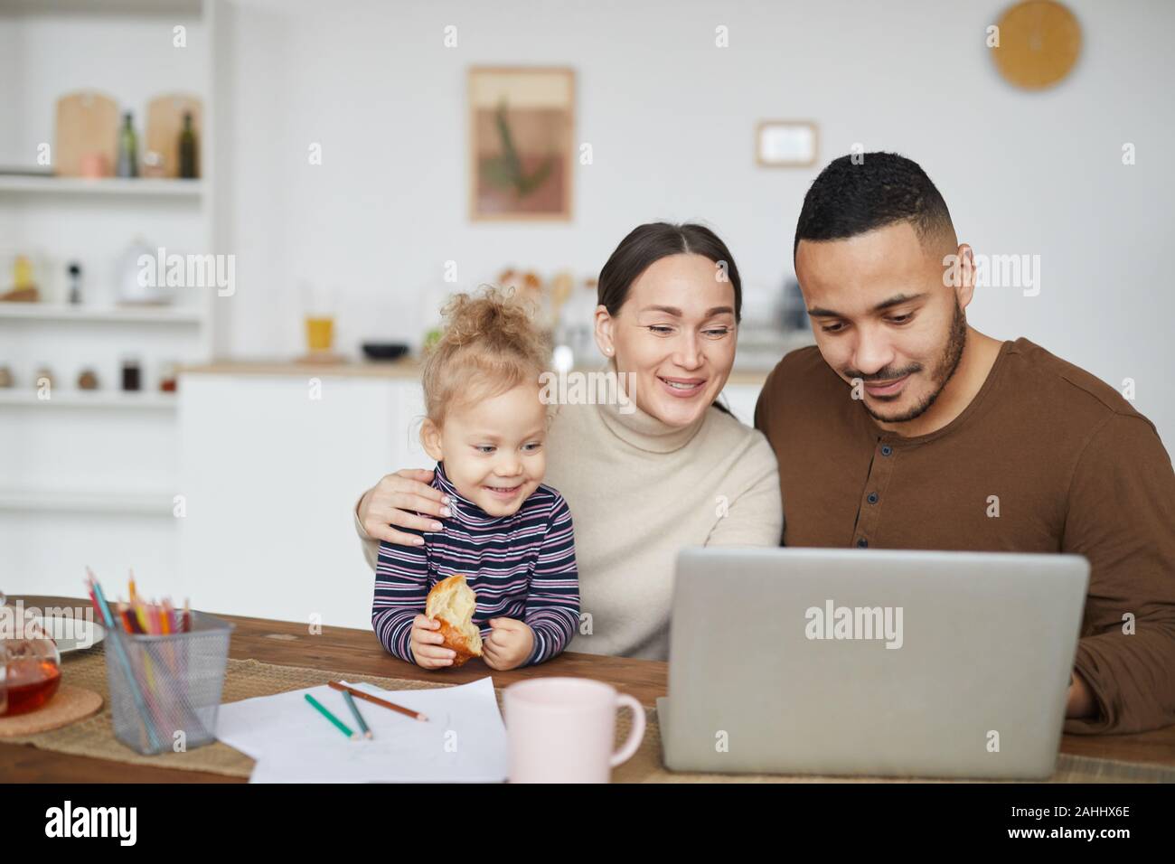 Ritratto di sorridere razza mista alla famiglia utilizzando laptop insieme mentre lo shopping online, spazio di copia Foto Stock