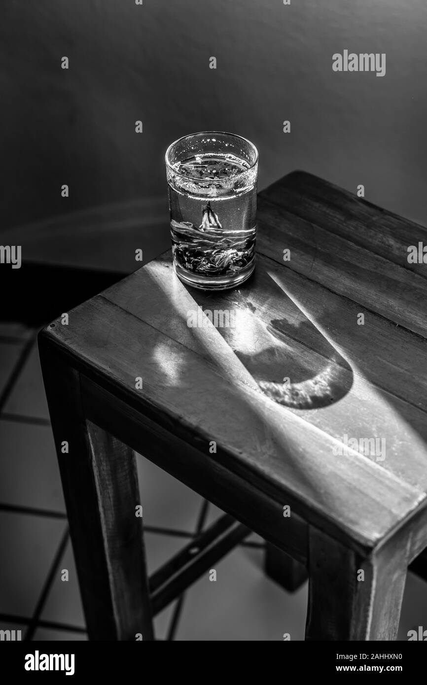 Vetro in piedi sulla sedia in ombra Foto Stock