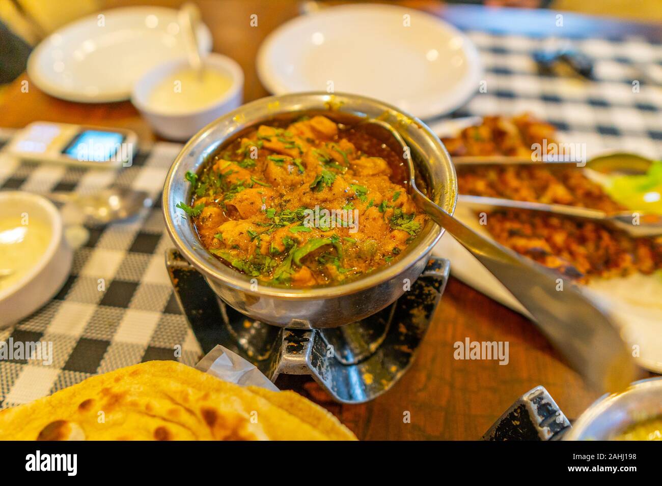 Acquolina in bocca tradizionali pakistane di colore arancione di agnello curry serviti in una ciotola con un cucchiaio Foto Stock