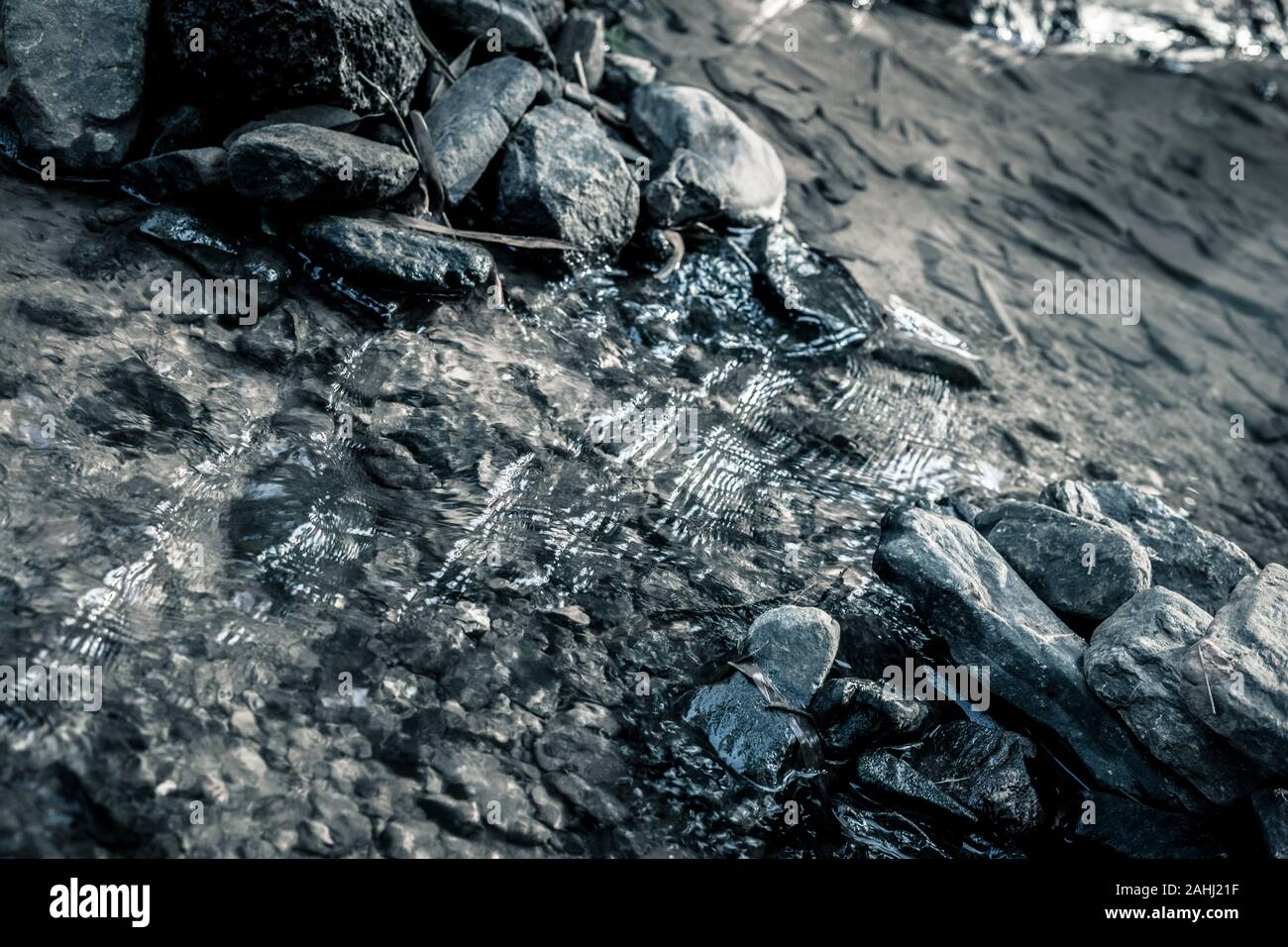 Close up di pietra che uso per rendere weir nel fiume con acqua vapore fluente, guardare dall'alto. Realizzato in tono drammatico Foto Stock