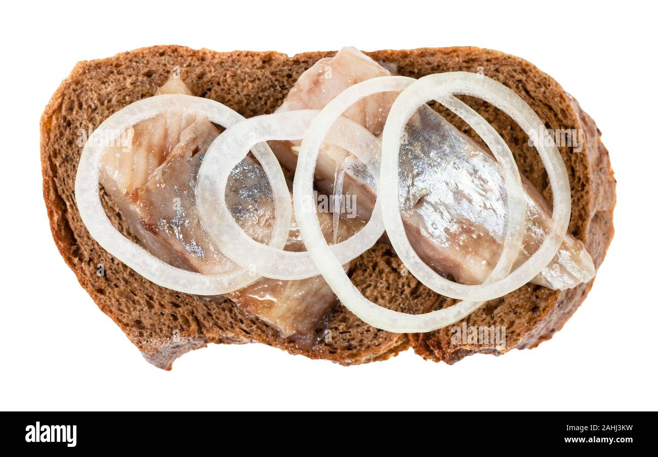 Vista superiore del sandwich aperto con pane di segale e aringhe in salamoia decorate di anelli di cipolla isolati su sfondo bianco Foto Stock