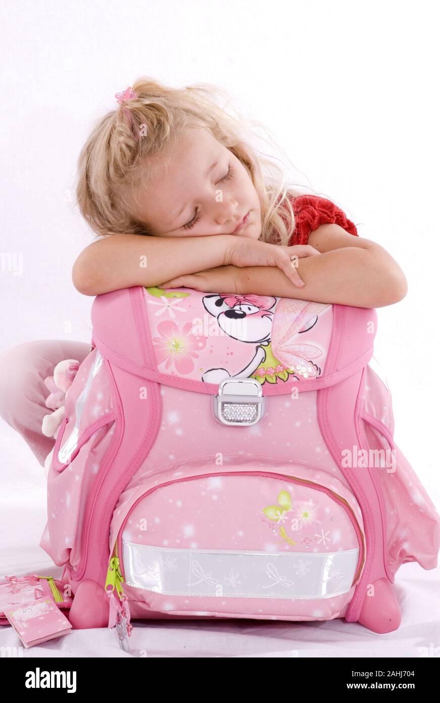 Bionde Schulmädchen, 6 Jahre alt, schläft auf Schulranzen, signor: Sì, Foto Stock