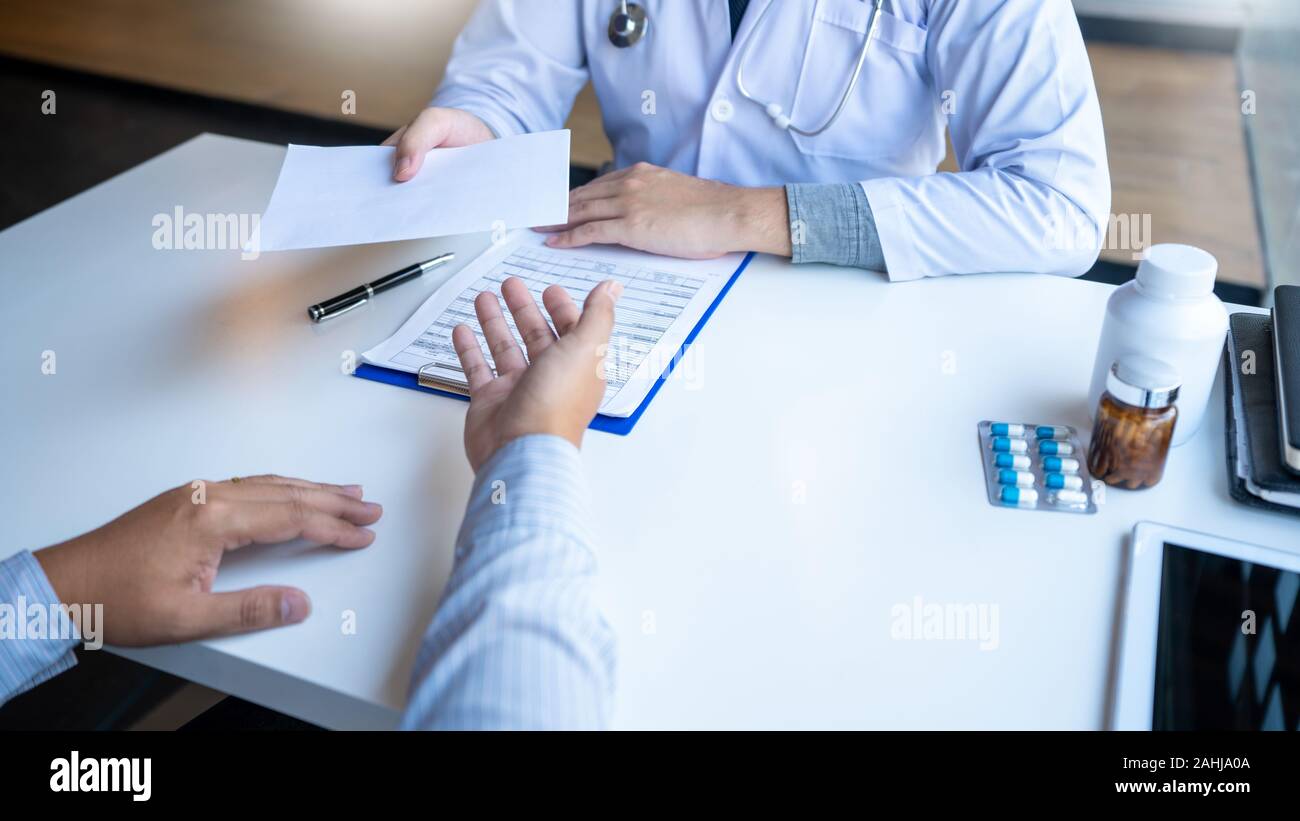 Medico spiegando e dando una consultazione per un paziente informazioni mediche e diagnosi circa il trattamento per condizioni all'ospedale, medici eth Foto Stock