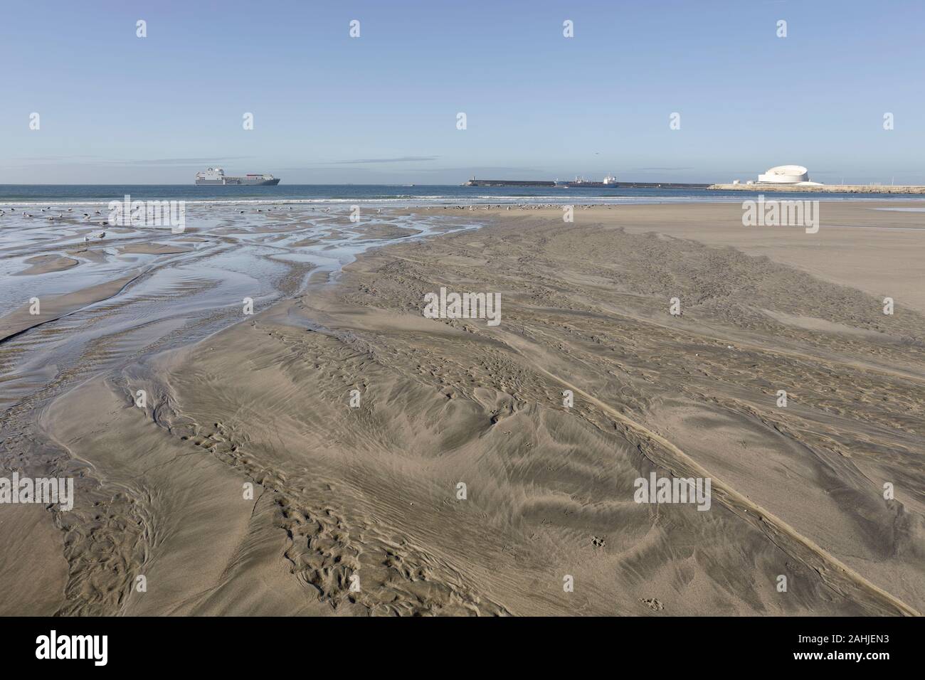 Spiaggia vuota durante la bassa marea. Spiaggia di Matosinhos vedendo Leixoes porto entrata. Foto Stock