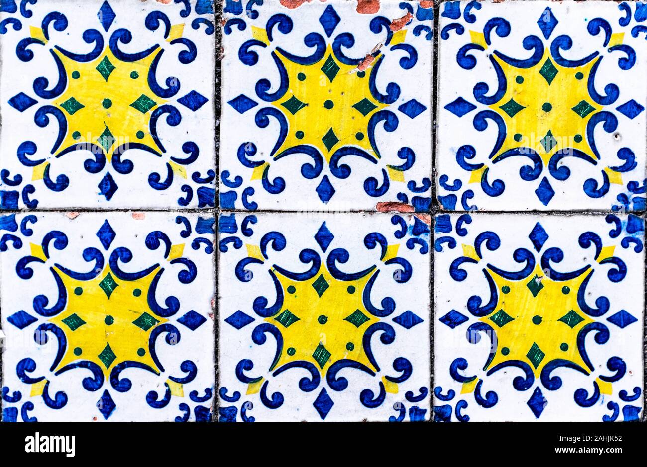 Portoghese piastrelle tradizionali con azulejos blu, verde e giallo modello geometrico su uno sfondo bianco. Foto Stock