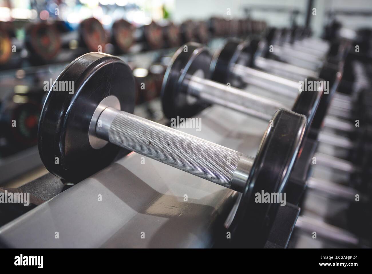 Basso peso Dumbbell messo sugli scaffali dei negozi nel centro fitness, con un po' di polvere su di esso Foto Stock