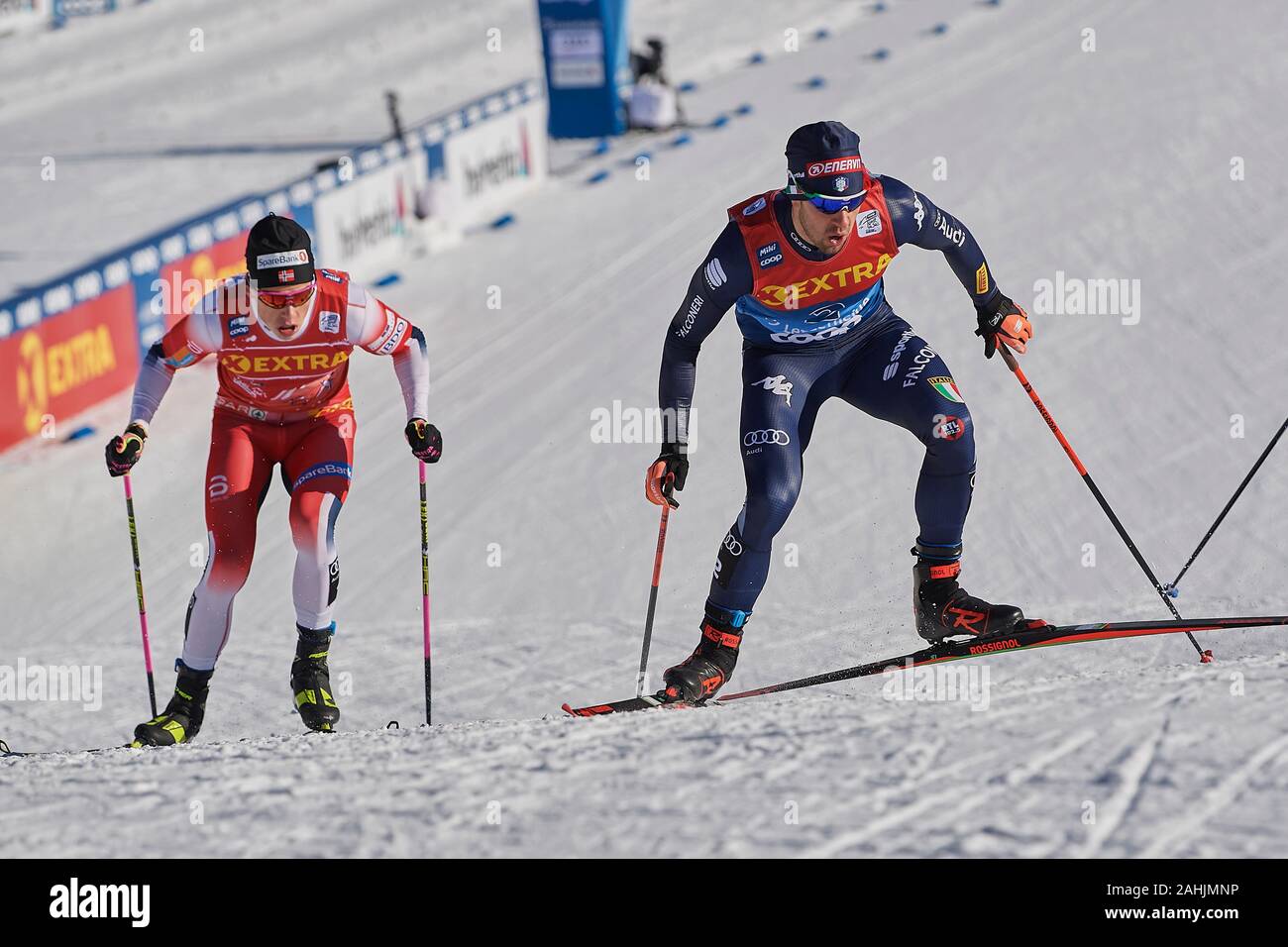 Lenzerheide, Schweiz, 29. Dezember 2019. Johannes Hoesflot Klaebo verfolgt Federico Pellegrino beim Sprint Rennen am FIS Langlauf Weltcup Tour de Ski Foto Stock