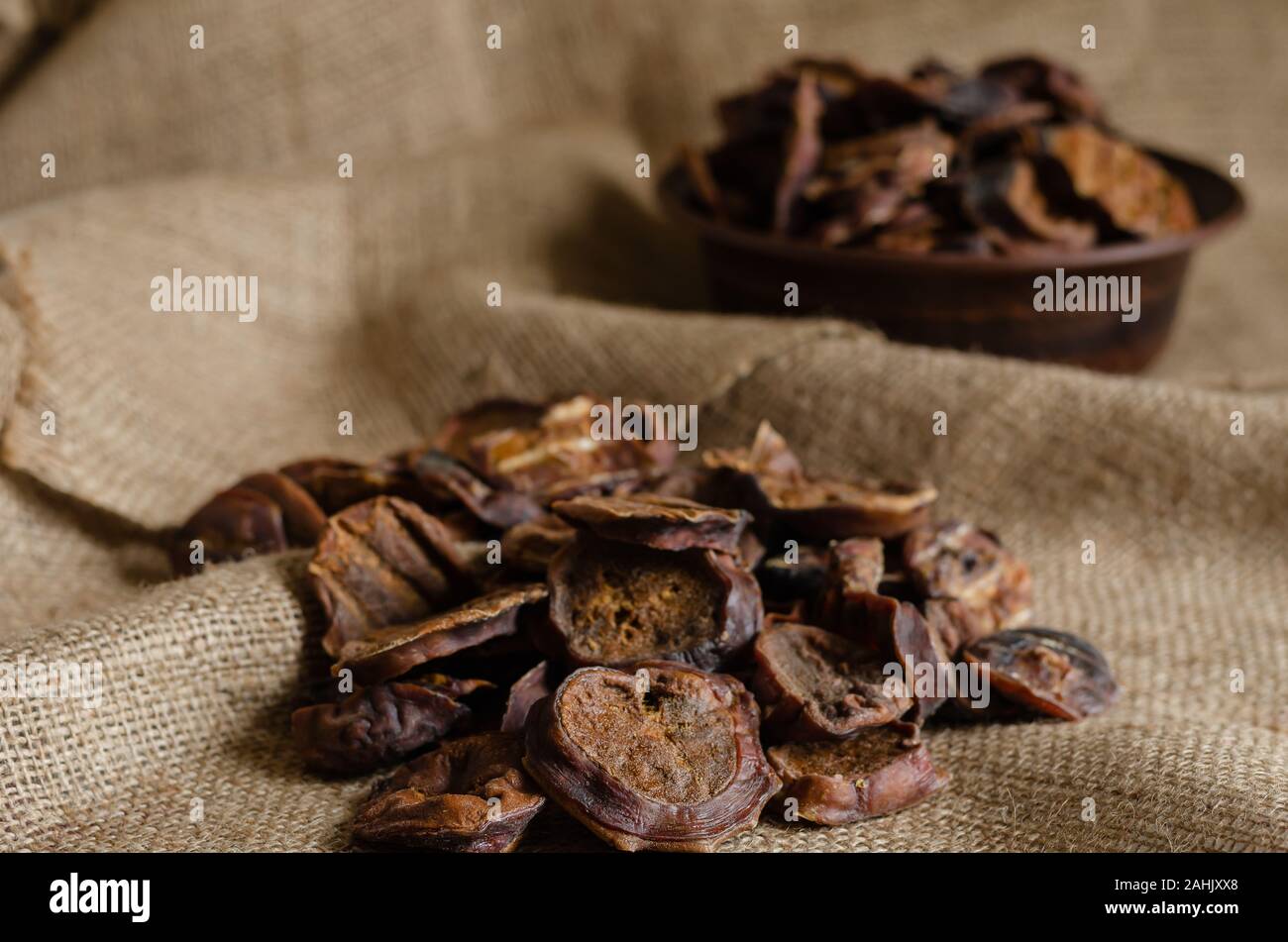 Un gruppo di essiccato bull testicoli in primo piano. In fondo è una ciotola  di argilla con affettato, goodies naturale. Close-up. Messa a fuoco  selettiva Foto stock - Alamy