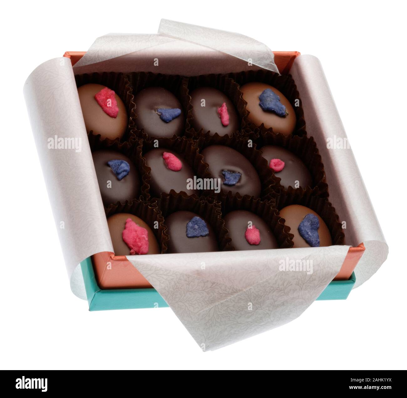 Una confezione aperta di rosa e viola la crema cioccolatini in una scatola. Il cioccolato al latte e cioccolato fondente creme fondente. Tre righe di quattro imballate ordinatamente in. Foto Stock