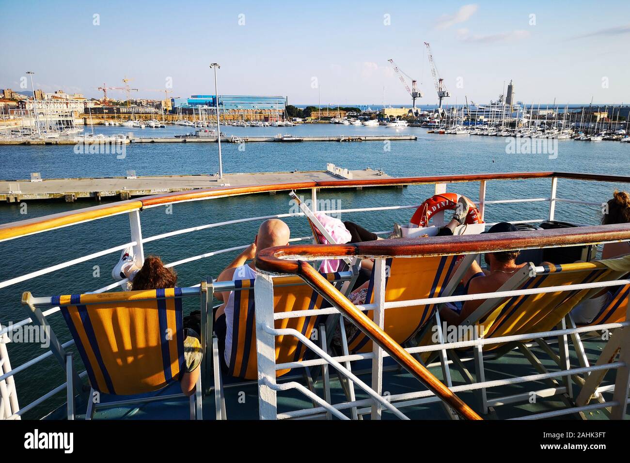 I passeggeri di un traghetto per rilassarsi sulle sedie a sdraio mentre andate in vacanza. Foto Stock