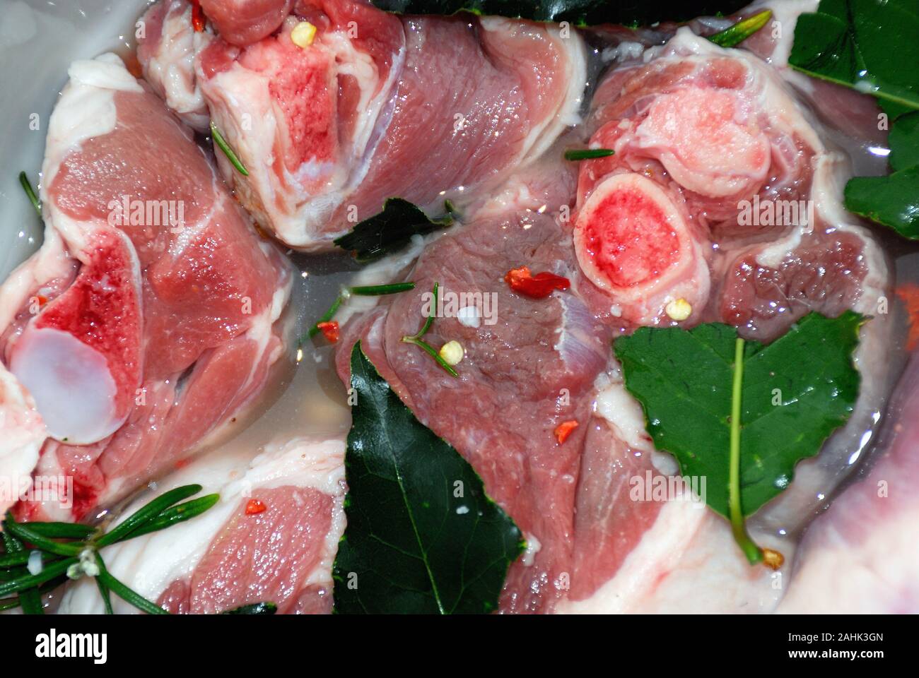 Cucina calabrese. Agnello sottaceto marinato con vino bianco, foglie di alloro, rosmarino e peperoncino rosso caldo. Foto Stock