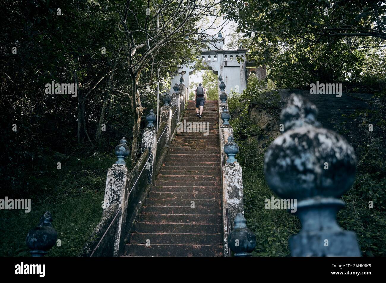 Giovane turista salite le scale fino alla porta del tempio antico vicino Tangalle. Mulkirigala, Sri Lanka. Foto Stock