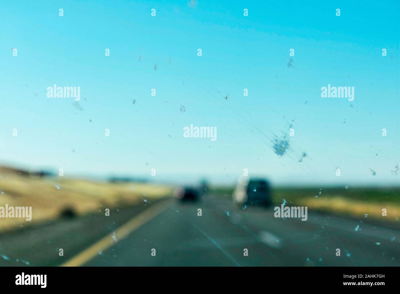 Macchina sporca vetro per finestra con gli insetti e sporcizia influiscono sulla visibilità del conducente durante la guida su autostrada diviso. Il usurato o guasto auto spazzole tergicristallo. Foto Stock