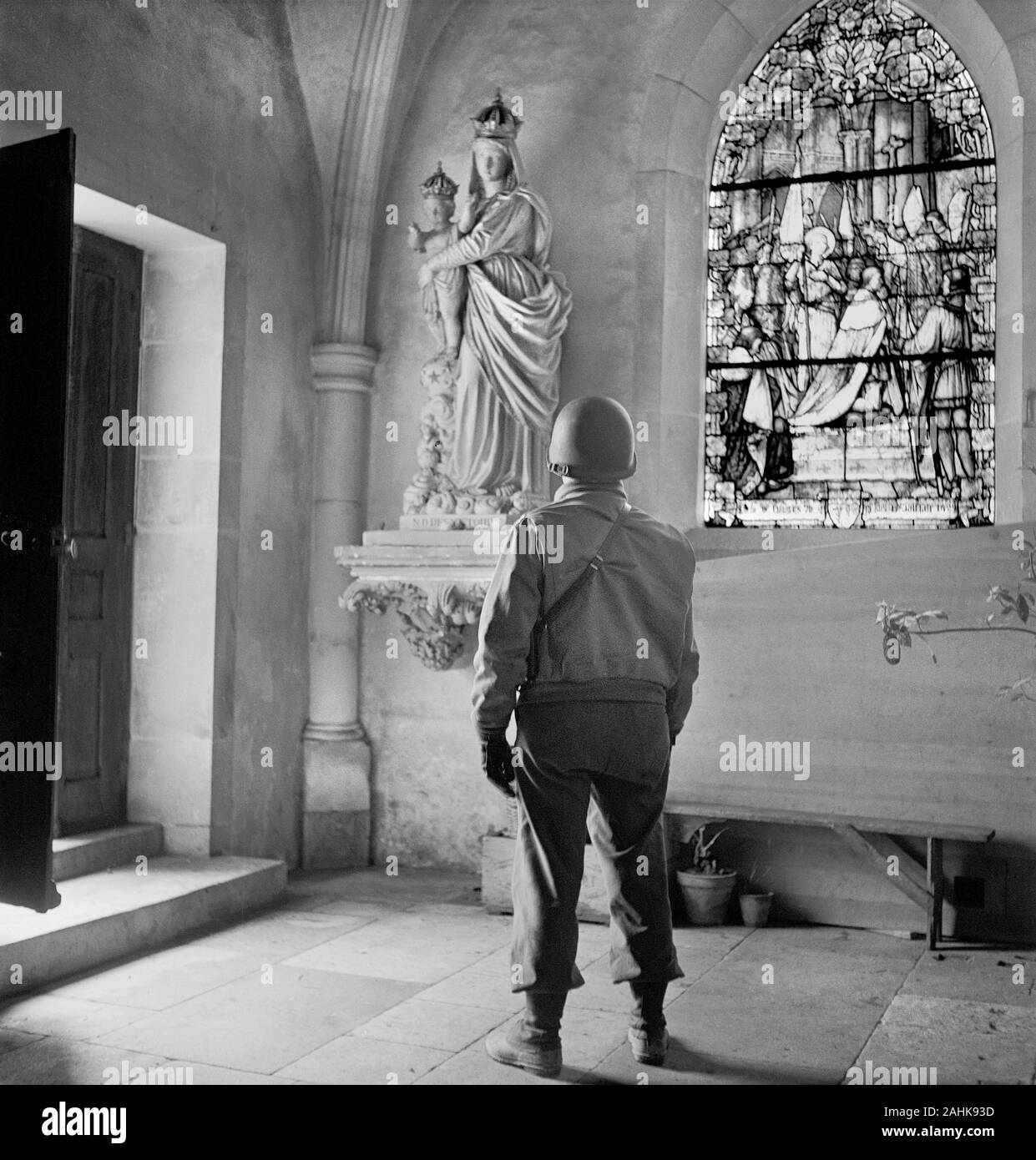 Soldato guardando una statua della Madonna e il bambino in una chiesa, probabilmente in Europa durante la II Guerra Mondiale, fotografia di Toni Frissell, inizio 1940 Foto Stock