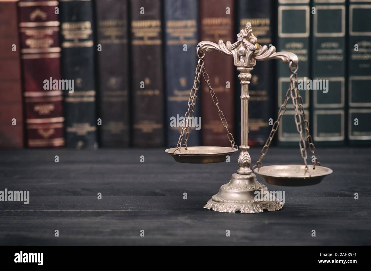Il diritto e la giustizia, il concetto di legalità, bilancia della giustizia su un nero lo sfondo di legno. Foto Stock
