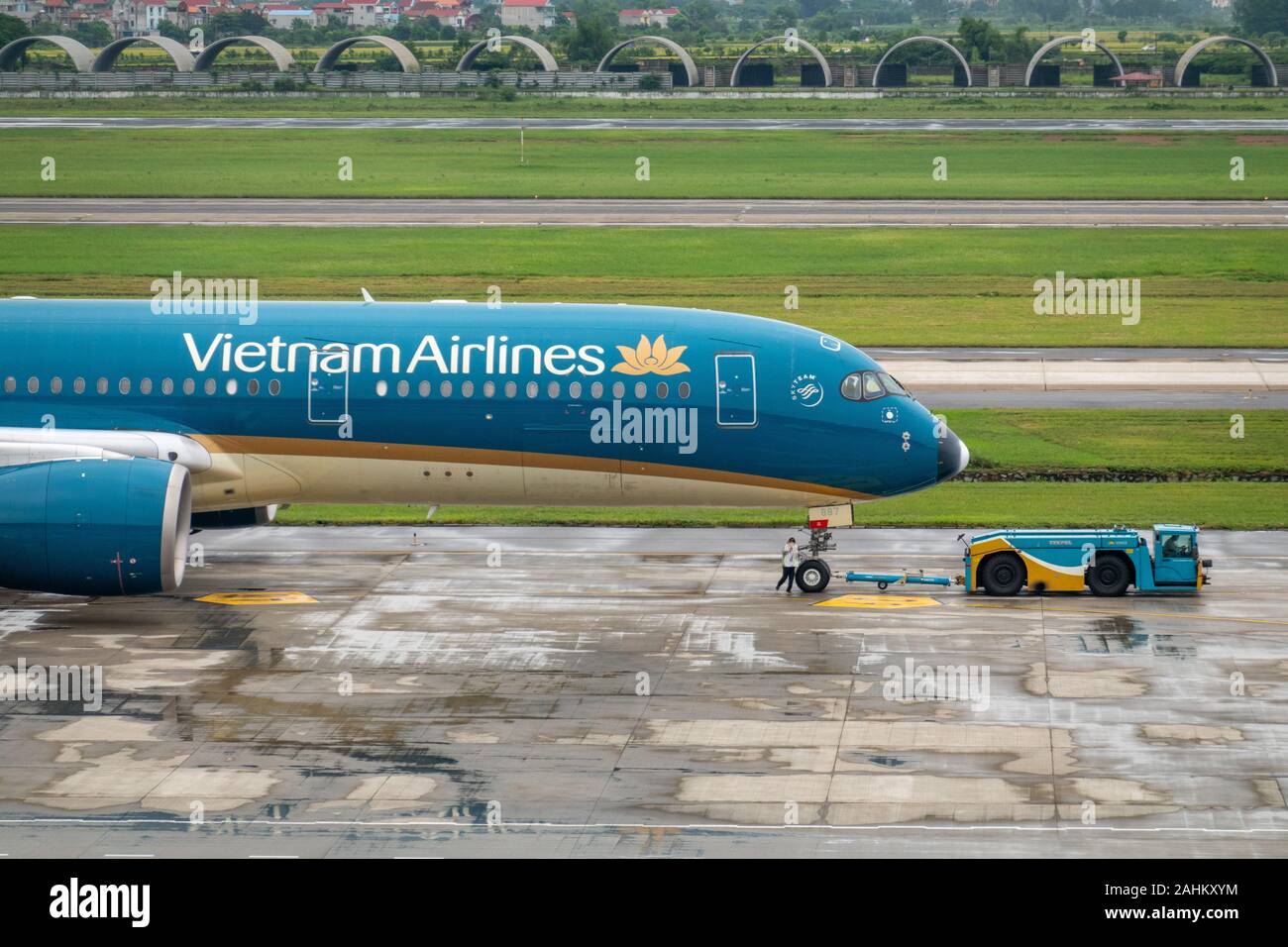 Personale di terra di comunicare per il ponte di volo di un aeromobile Airbus A350-900 del Vietnam Airlines all'Aeroporto Internazionale di Noi Bai, Hanoi, Vietnam Foto Stock