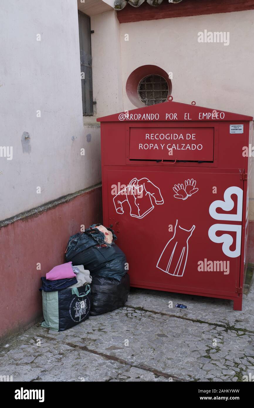 Rifiuti vicini a un contenitore per il riciclaggio dei panni in Spagna Foto Stock