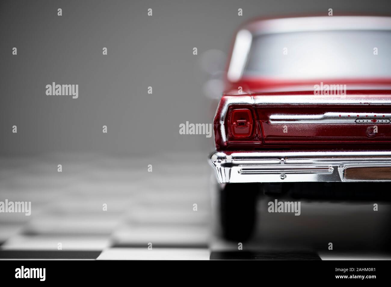 Izmir, Turchia - 27 dicembre 2019: vista posteriore di un colore rosso 1960 Chevrolet Nova modello giocattolo auto su un terreno a scacchi. Foto Stock