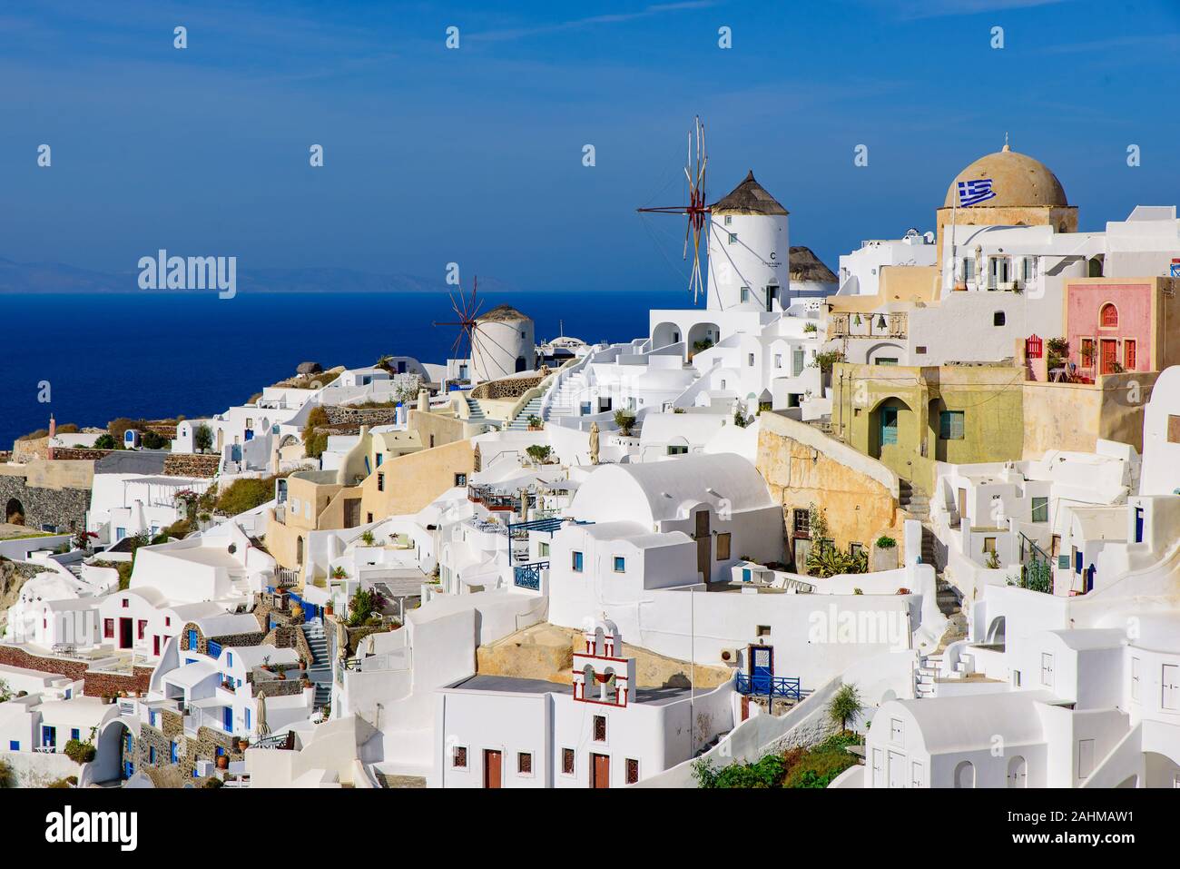 Il mulino a vento e tradizionali edifici bianco rivolta verso il mare mediterraneo in Oia - Santorini, Grecia Foto Stock