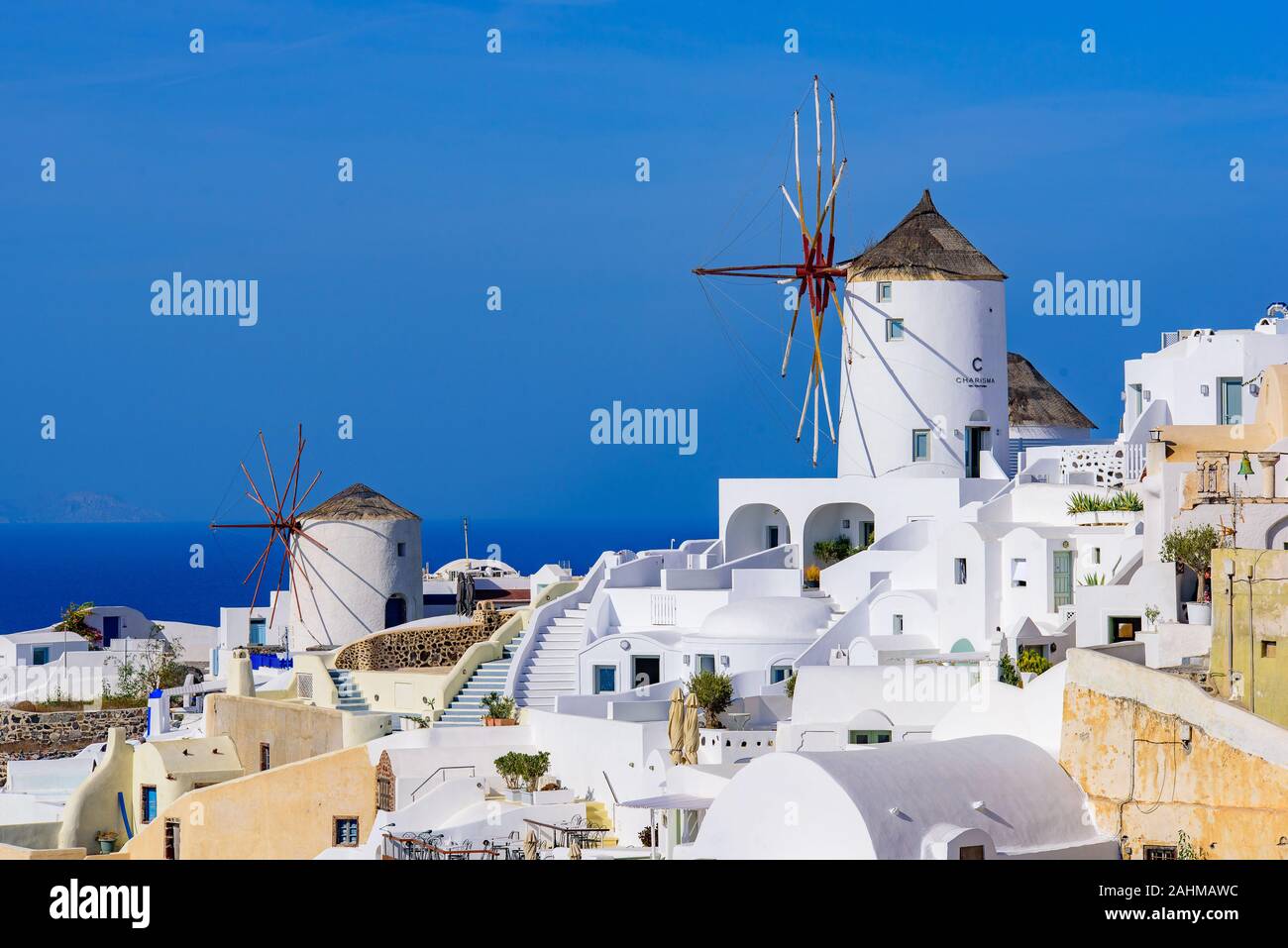 Il mulino a vento e tradizionali edifici bianco rivolta verso il mare mediterraneo in Oia - Santorini, Grecia Foto Stock
