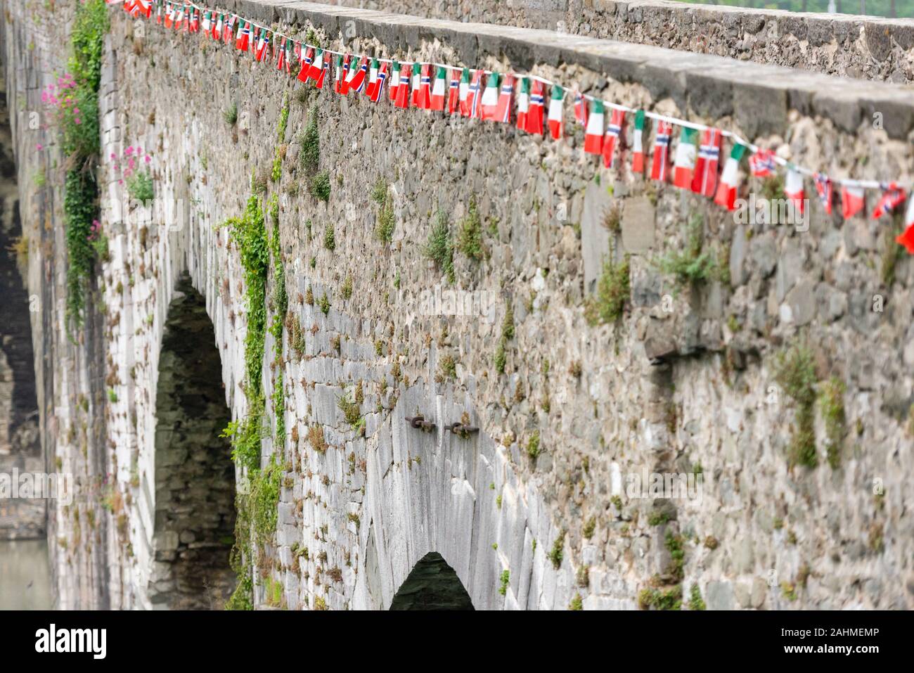 Ponte del diavolo. Ponte sul fiume in Toscana. Costruito nel 11 secolo. Bandiere sul ponte humpback. Foto Stock