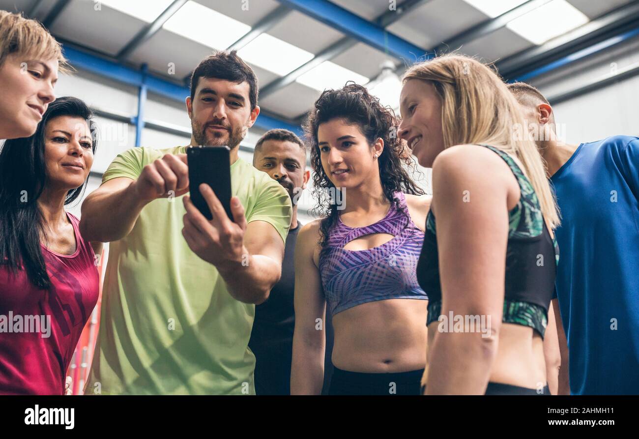 Gli atleti che cercano al mobile di una palestra mate Foto Stock