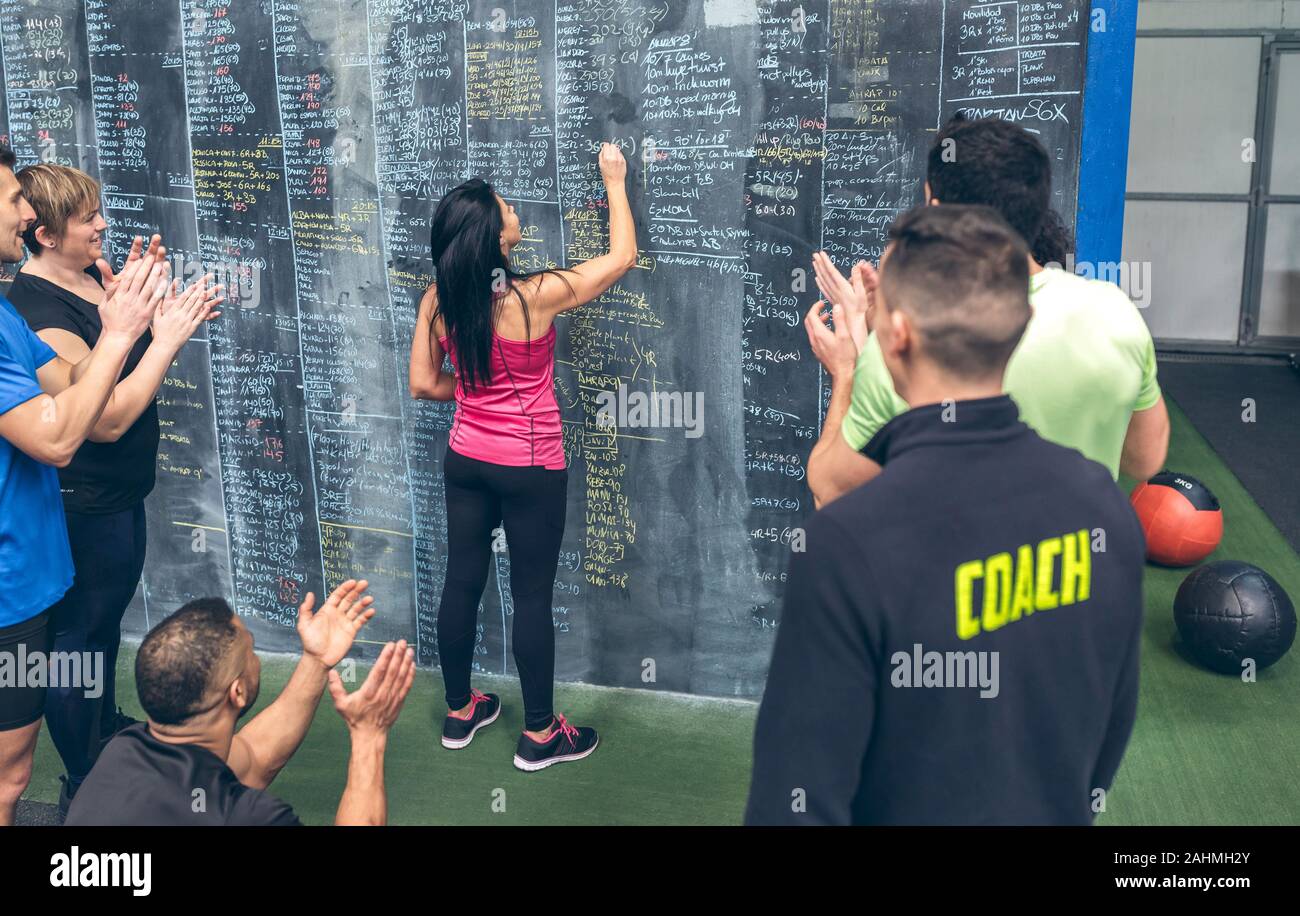 Atleta donna a scrivere i risultati sulla palestra di Blackboard Foto Stock