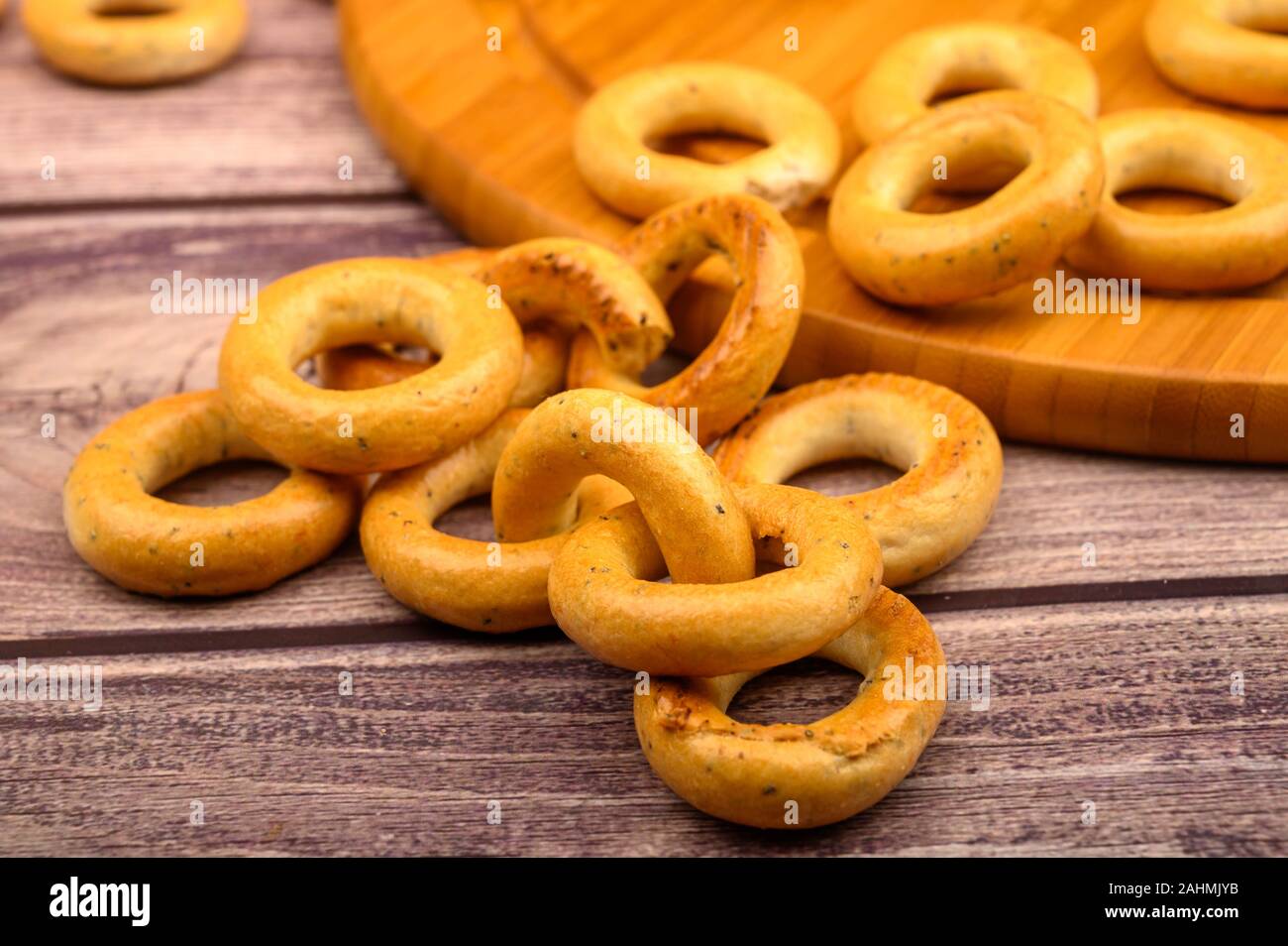 Un mazzetto di piccole ciambelle di pane su un sfondo di legno Foto Stock