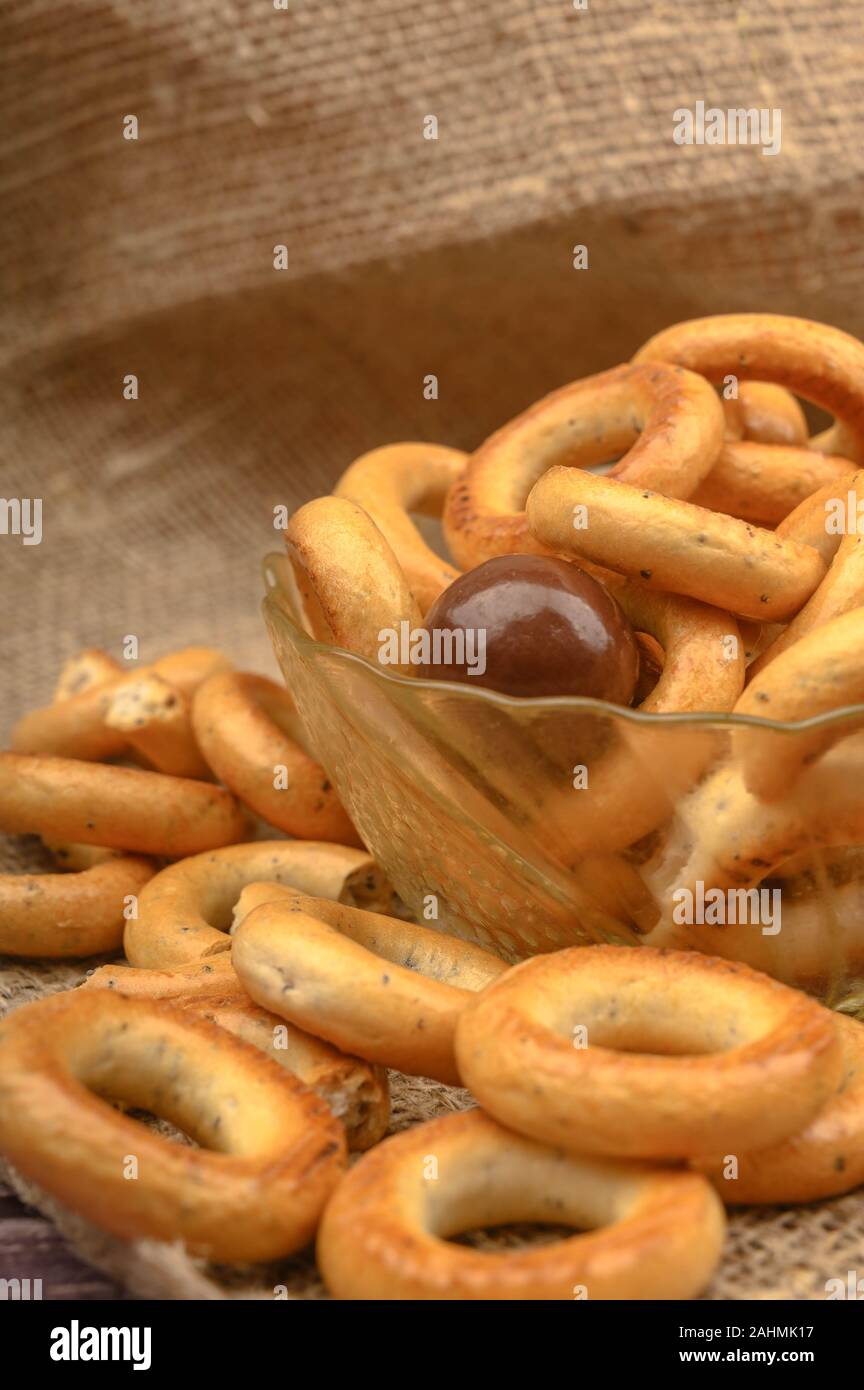Piccole ciambelle, lo zucchero di canna e piatti in ceramica su uno sfondo di legno di close-up Foto Stock