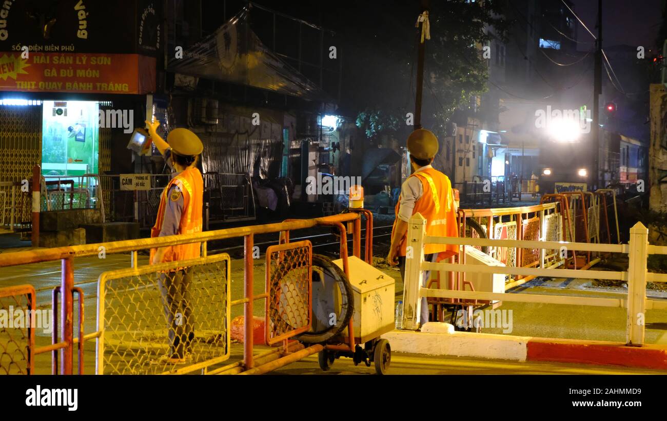 Hanoi (Vietnam) Città di notte con il treno che passa direttamente attraverso il case. Diverse luci e riflessi catturati nella foto. Foto Stock