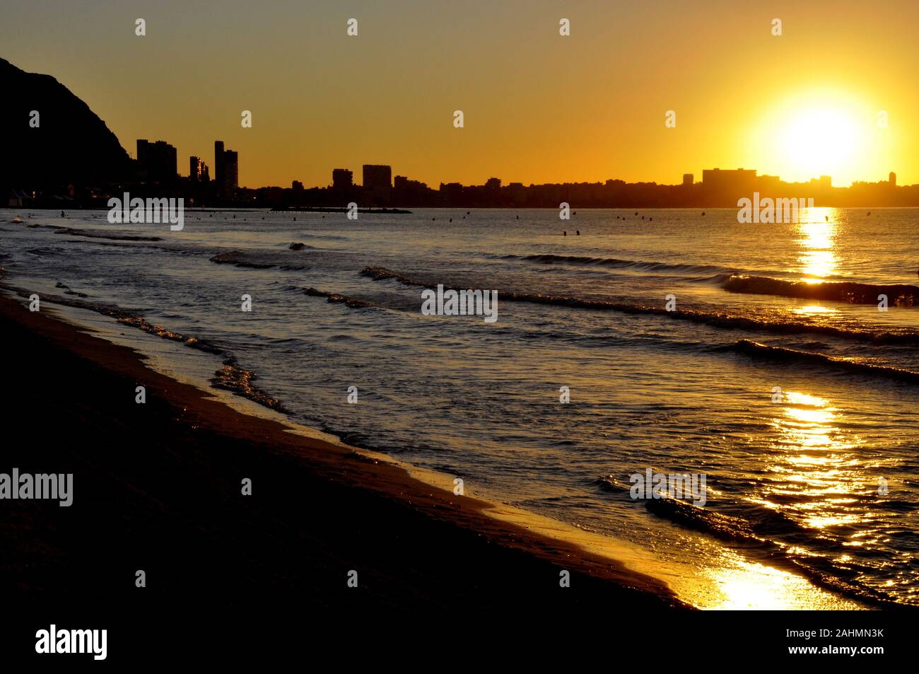 La mattina presto sorgere del sole su di una spiaggia di sabbia in Alicante Spagna Foto Stock