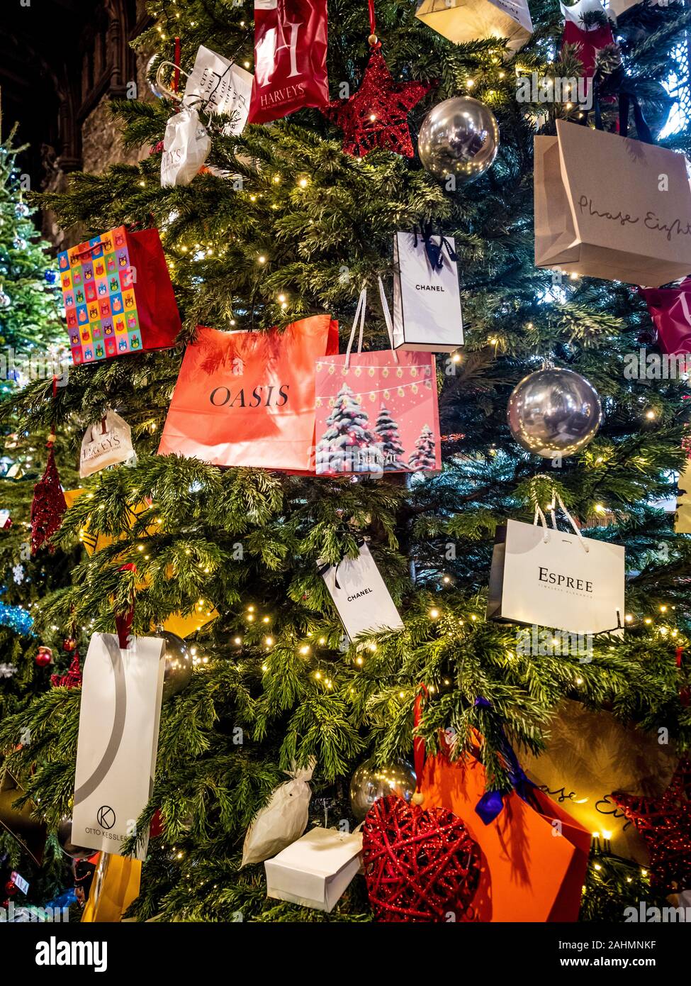 Borse per lo shopping con il designer i nomi di marca appeso su albero di Natale. Foto Stock