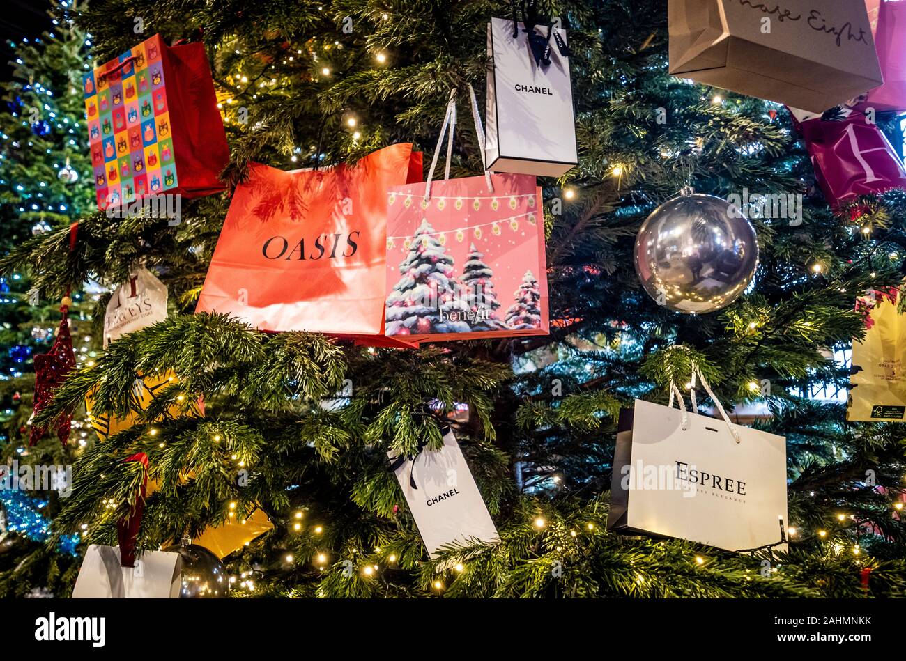 Borse per lo shopping con il designer i nomi di marca appeso su albero di Natale. Foto Stock